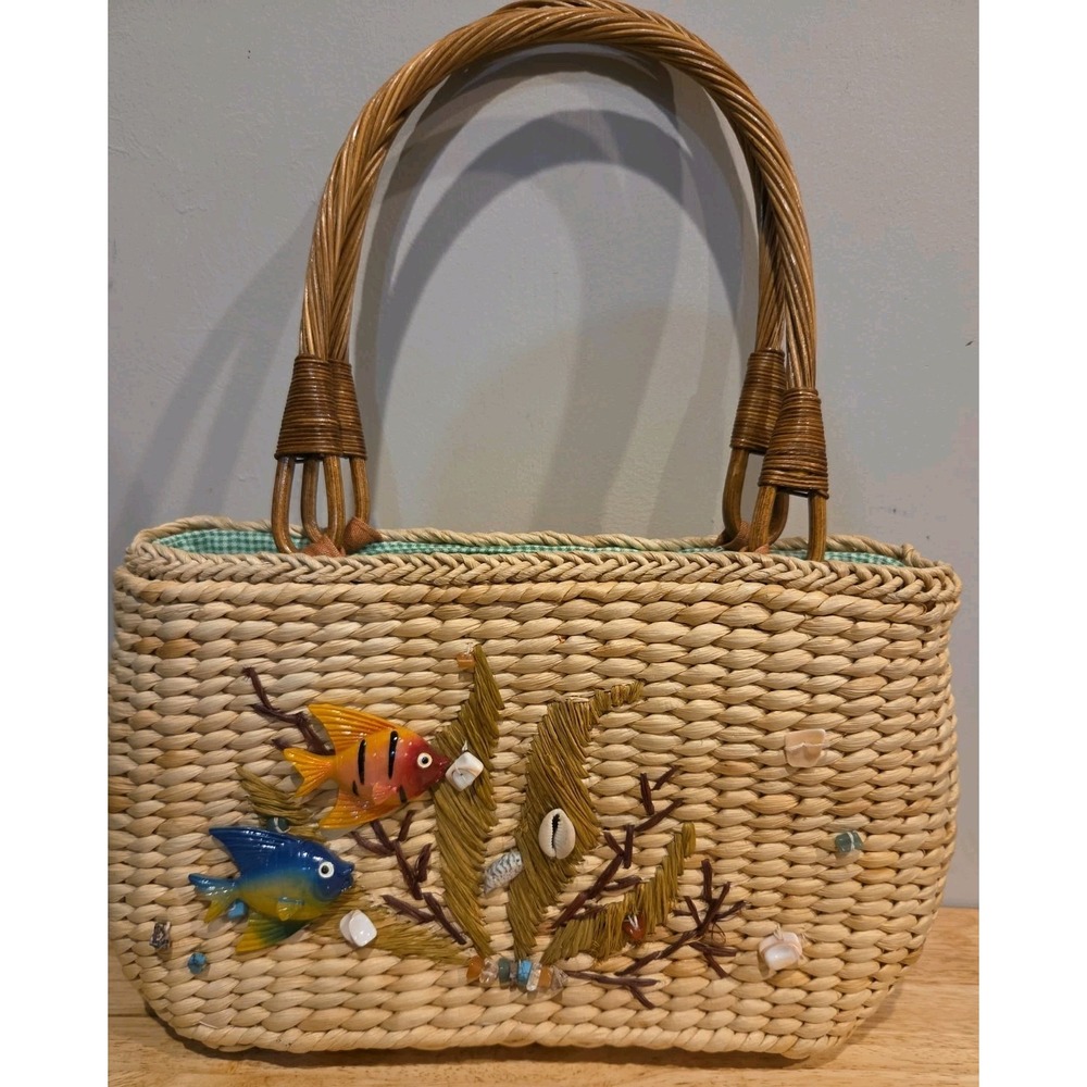 woven straw beach tote bag decorated with resin fish and shells.